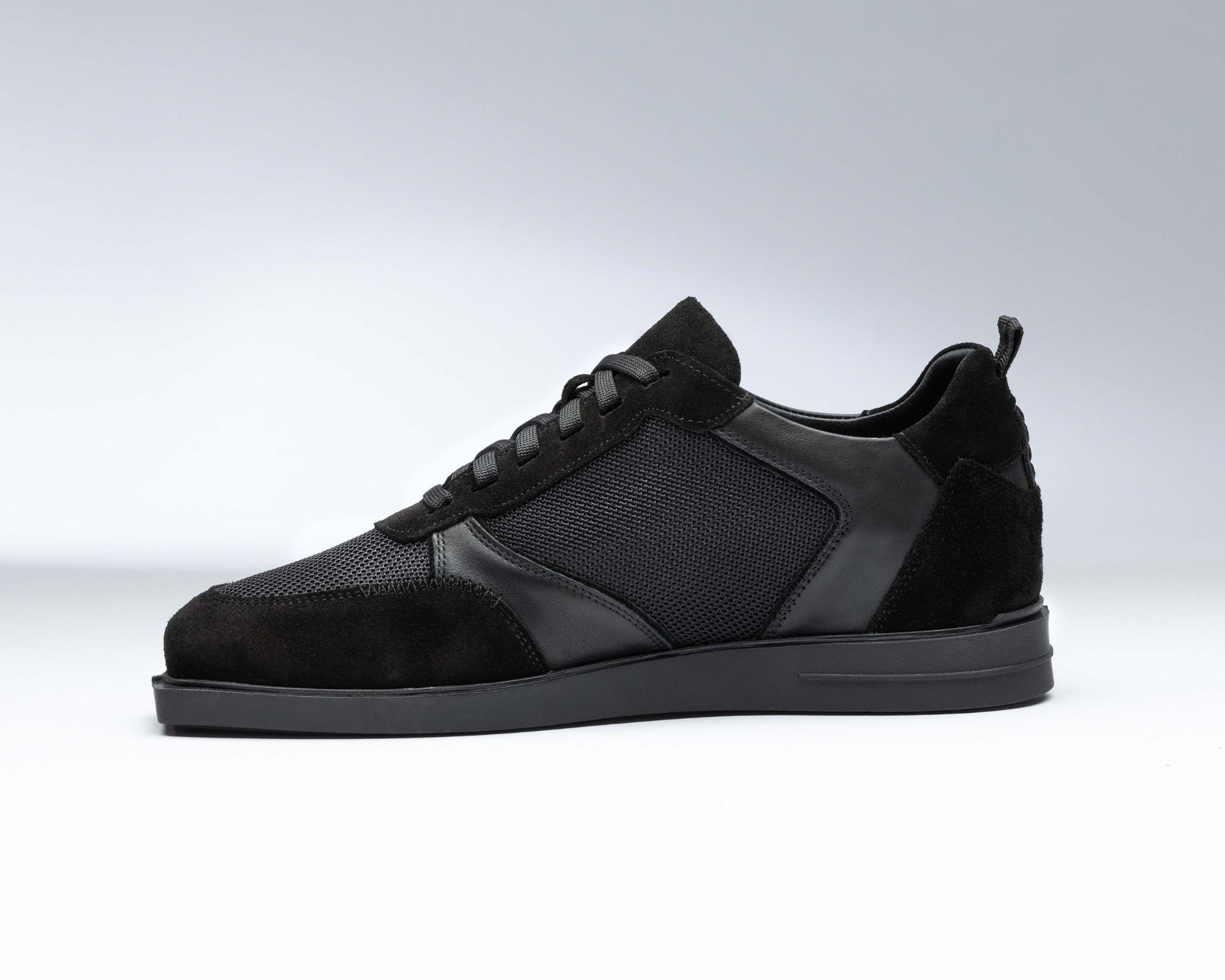 Innenansicht eines rechten Schuhs von triple20. Dieser junge, innovative Hersteller hat 2022 patentierte Dartschuhe auf den Markt gebracht und begeistert seither mit seiner Idee die Dartszene, ob Hobbyspieler oder Profi. Der gezeigte Schuh ist komplett schwarz inklusive der Sohle. Das Material besteht aus echtem Leder und Mesh.